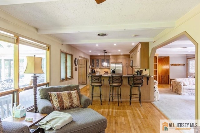 57 Jensen St, East Brunswick, NJ 08816 - kitchen featuring stainless steel fridge, beam ceiling, a kitchen breakfast bar, a peninsula, and glass insert cabinets