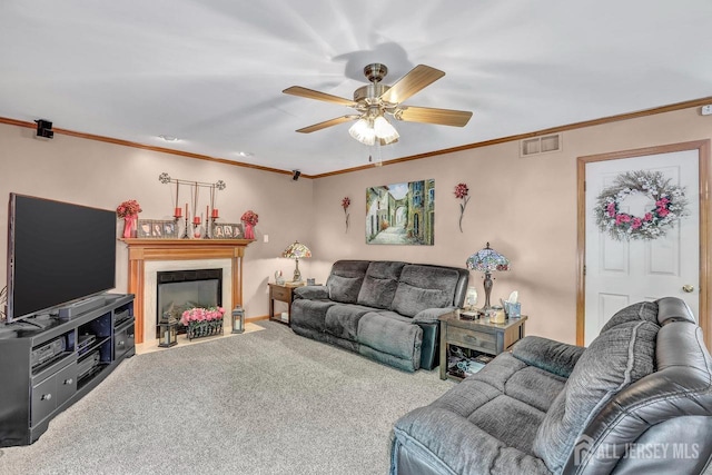 living room with carpet, a fireplace with flush hearth, crown molding, a ceiling fan, and baseboards