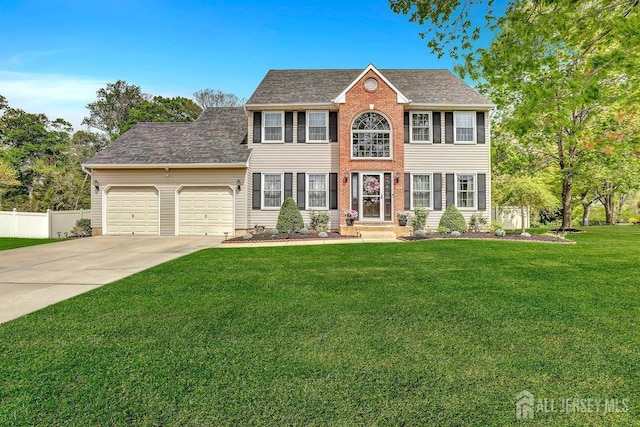 colonial home with a garage, driveway, and roof with shingles