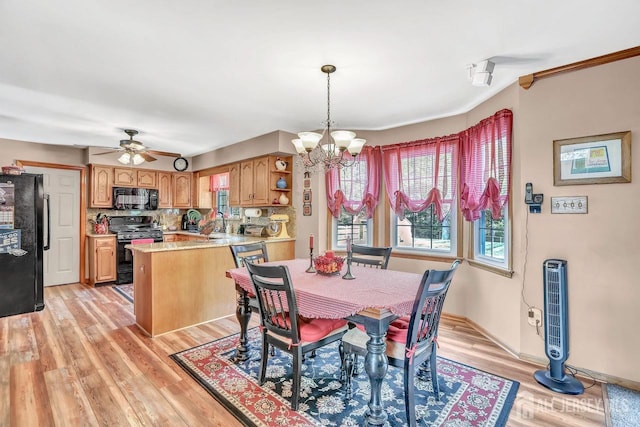 dining room with a chandelier, light wood-style floors, ceiling fan, and baseboards