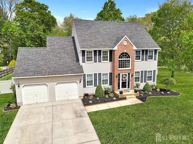 colonial-style house featuring concrete driveway, an attached garage, and roof with shingles
