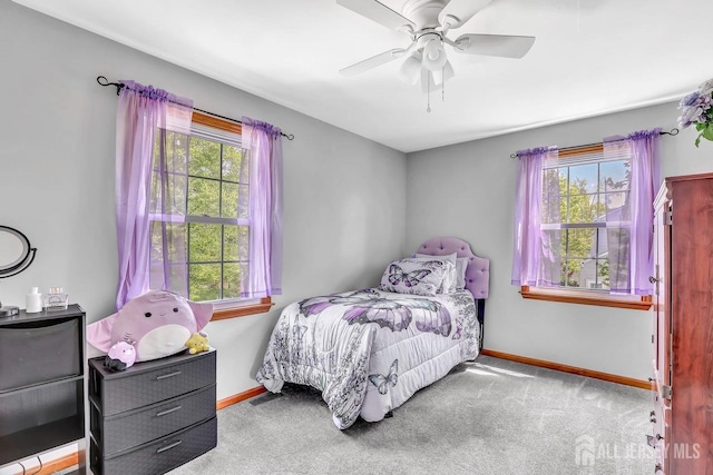 carpeted bedroom with multiple windows, baseboards, and ceiling fan