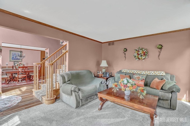 carpeted living room featuring crown molding and stairs