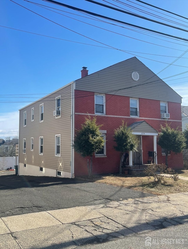 exterior space featuring a chimney and cooling unit