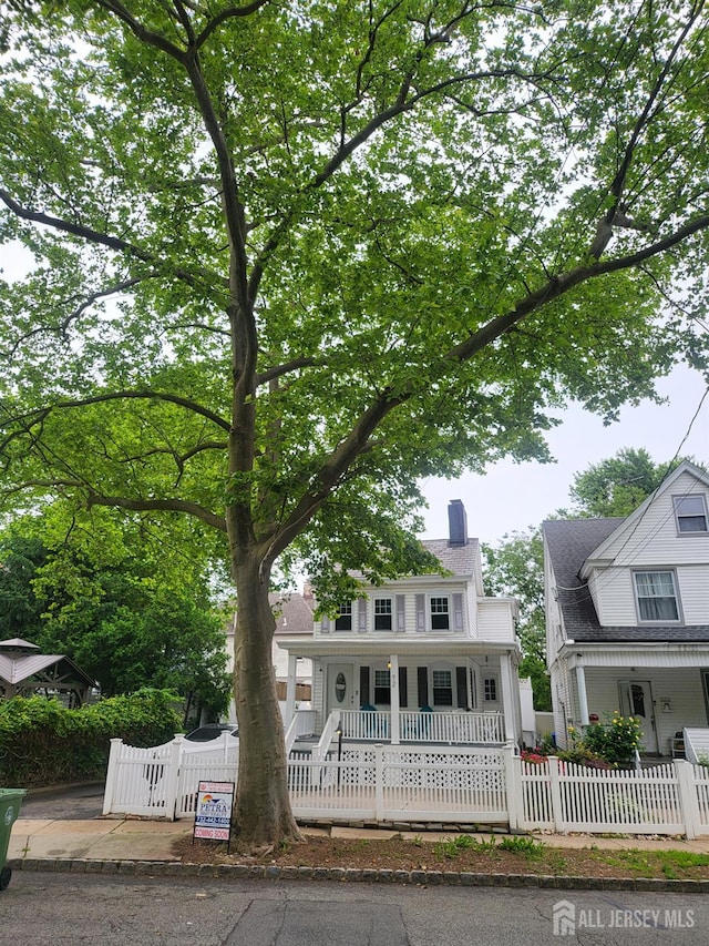 72 High St, Perth Amboy, NJ 08861 - view of front of home featuring covered porch, a chimney, and a fenced front yard