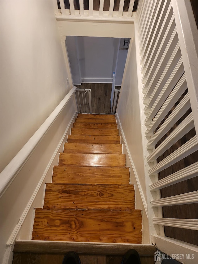 72 High St, Perth Amboy, NJ 08861 - staircase featuring wood finished floors and baseboards