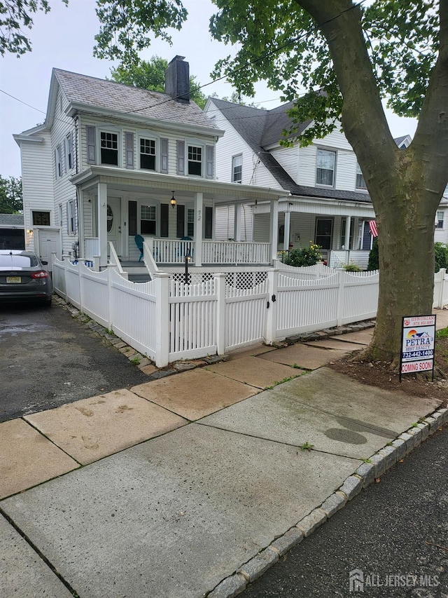 72 High St, Perth Amboy, NJ 08861 - view of front of property with a porch, a chimney, and a fenced front yard