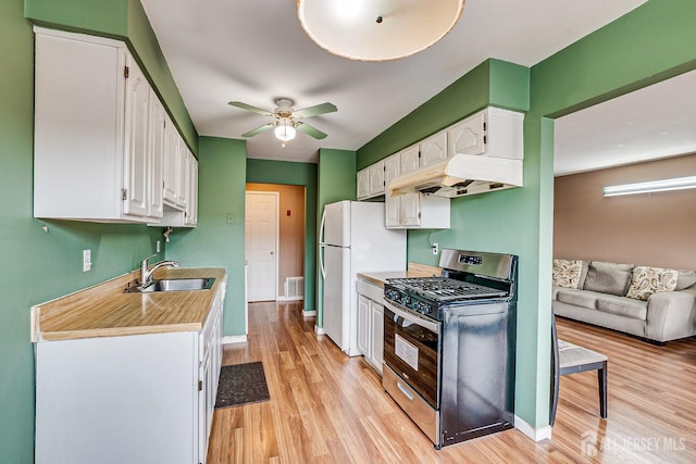 kitchen featuring white cabinetry, white refrigerator, stainless steel range with gas stovetop, and sink