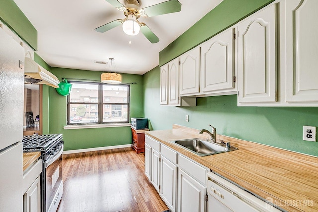 kitchen with white cabinetry, decorative light fixtures, light wood-type flooring, white appliances, and sink