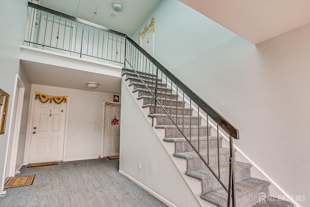 staircase featuring a towering ceiling