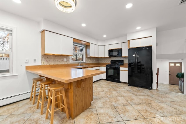 2291 Morrison Ave, Union Twp, NJ 07083 - kitchen featuring black appliances, baseboard heating, a peninsula, a sink, and backsplash