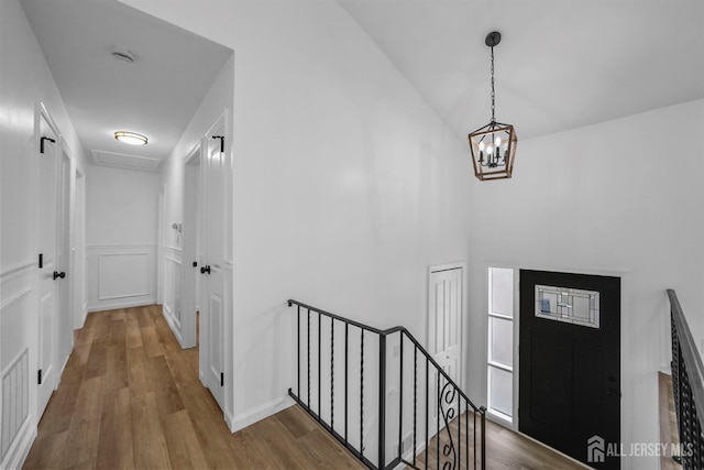 foyer with hardwood / wood-style floors and a chandelier