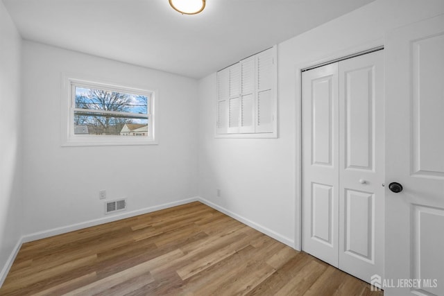 unfurnished bedroom with hardwood / wood-style flooring and a closet