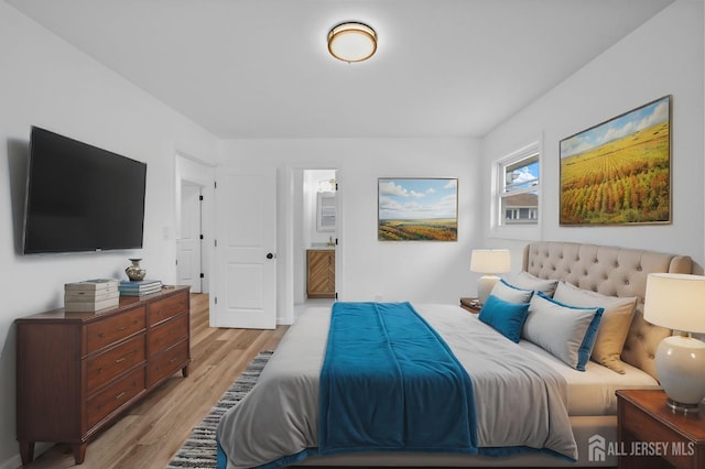 bedroom featuring ensuite bath and light hardwood / wood-style flooring