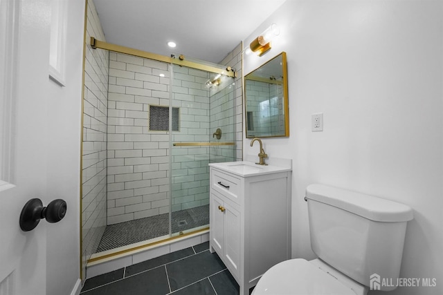 bathroom with toilet, vanity, tile patterned floors, and a shower with shower door