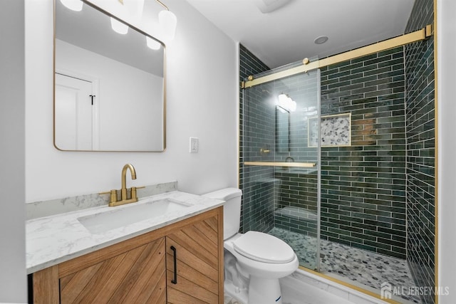 bathroom with walk in shower, vanity, and toilet