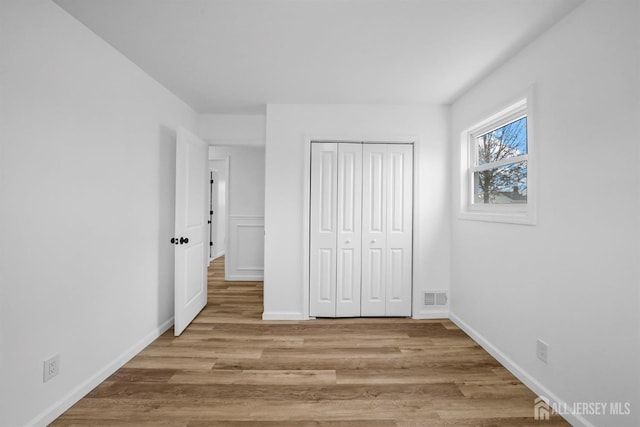 unfurnished bedroom with light hardwood / wood-style floors and a closet