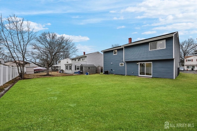 back of property with cooling unit and a lawn