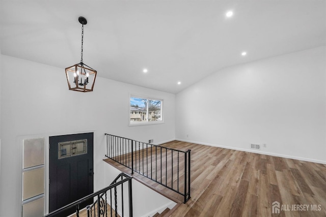 interior space with vaulted ceiling, a chandelier, and light hardwood / wood-style floors