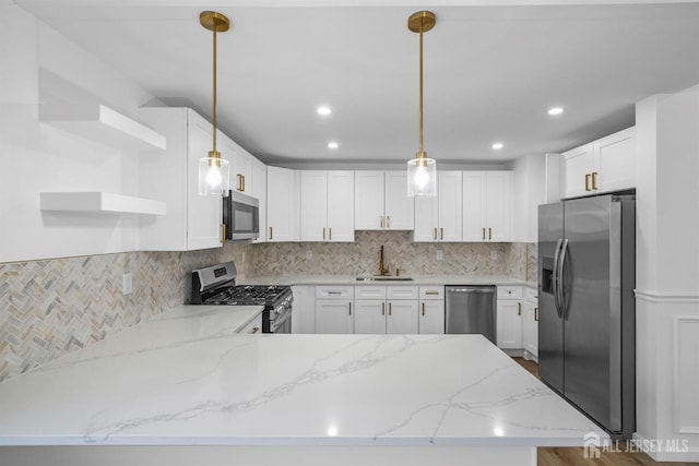 kitchen with white cabinetry, stainless steel appliances, and decorative light fixtures