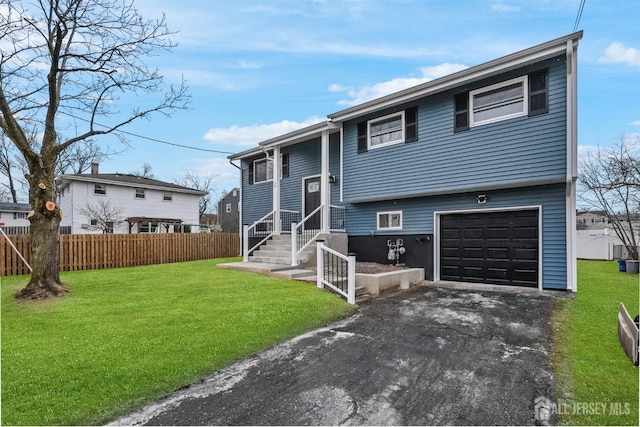 bi-level home featuring a garage and a front lawn