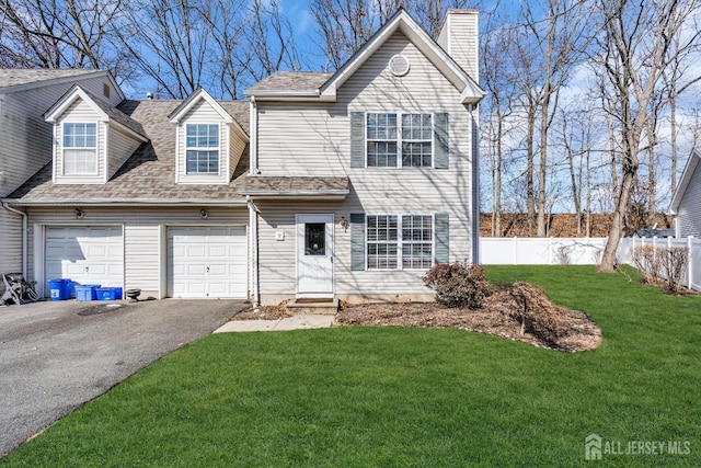 view of front of home featuring aphalt driveway, fence, a front yard, a garage, and a chimney