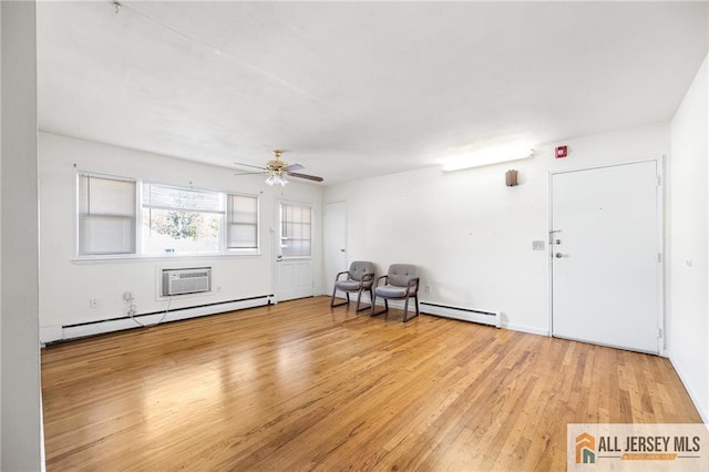 interior space featuring ceiling fan, baseboard heating, a wall mounted AC, and light wood-style floors