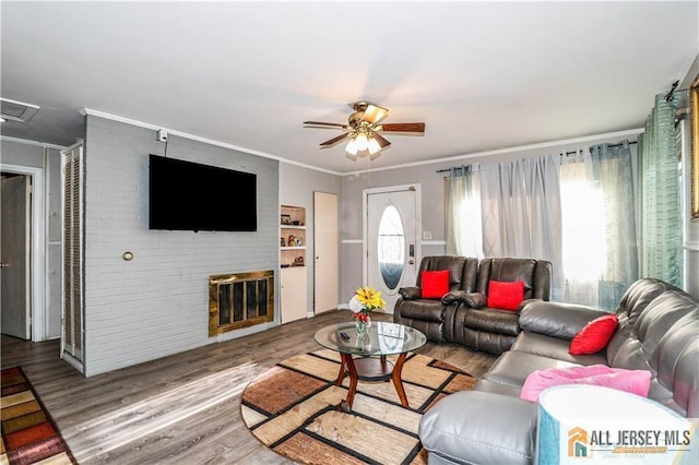 living room featuring ceiling fan, hardwood / wood-style floors, crown molding, and plenty of natural light