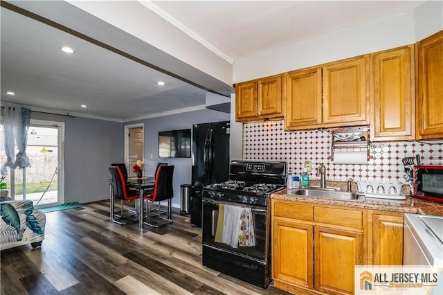 kitchen featuring backsplash, dark wood-type flooring, black appliances, and sink