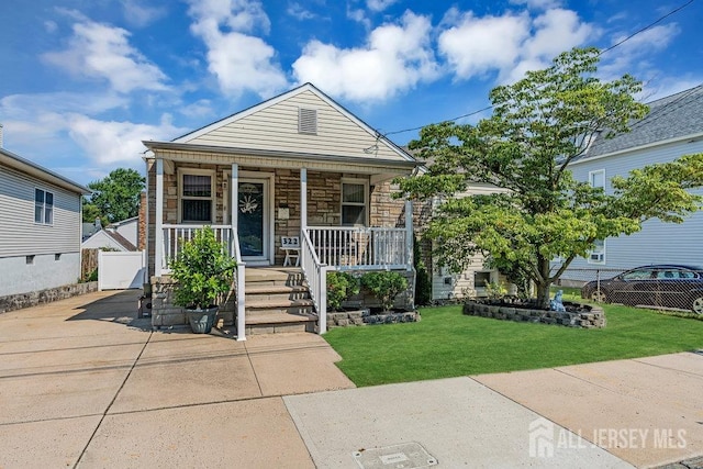 bungalow with a front lawn and a porch