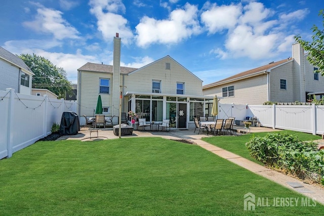 back of house featuring a patio area, a sunroom, and a yard