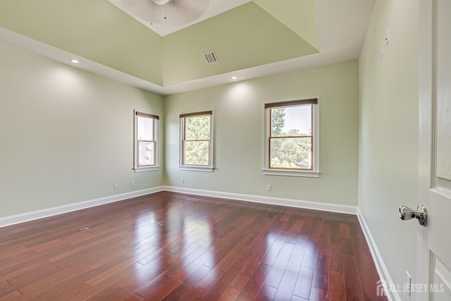 empty room featuring dark wood-style floors, baseboards, visible vents, and ceiling fan