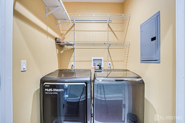 clothes washing area with laundry area, electric panel, and separate washer and dryer