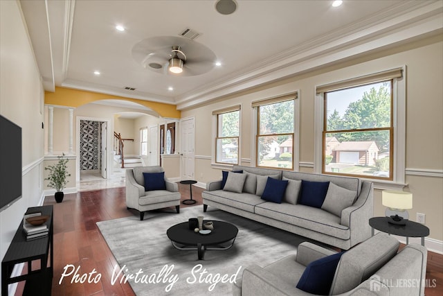 living room featuring arched walkways, stairway, dark wood-style flooring, and visible vents