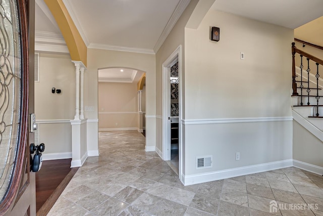 entryway with arched walkways, visible vents, stairway, and baseboards