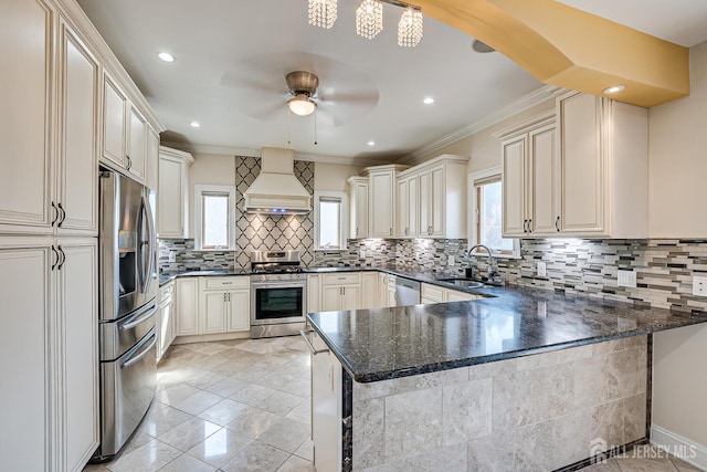 kitchen with tasteful backsplash, a peninsula, custom exhaust hood, stainless steel appliances, and a sink