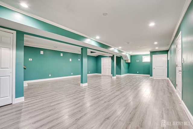 basement with baseboards, light wood-style floors, and crown molding