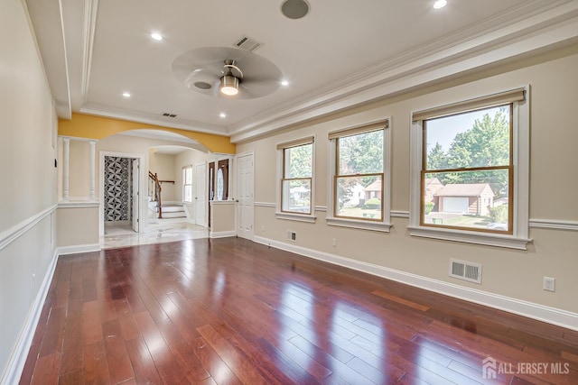 unfurnished living room with wood-type flooring, visible vents, and a healthy amount of sunlight