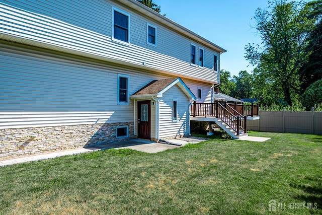 back of house with stairs, fence, a lawn, and a wooden deck