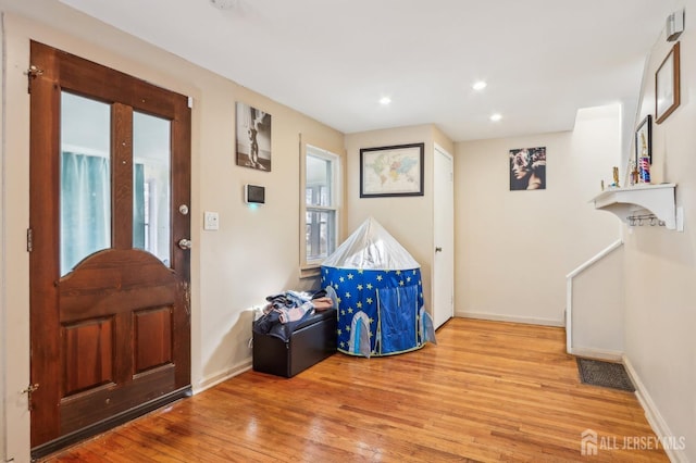 foyer with recessed lighting, visible vents, baseboards, and wood finished floors