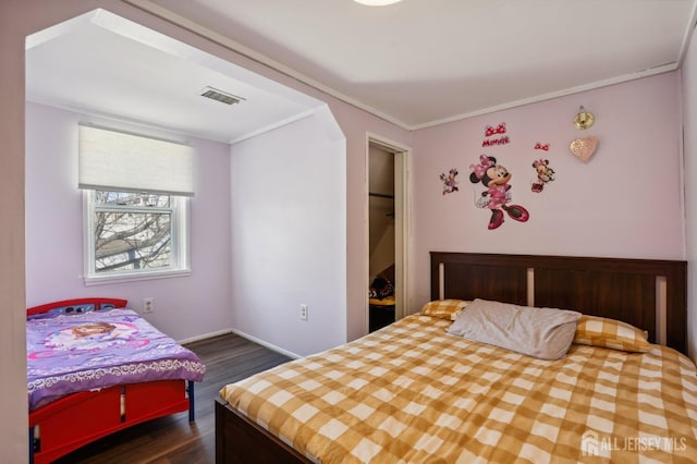 bedroom featuring visible vents, dark wood-type flooring, and ornamental molding