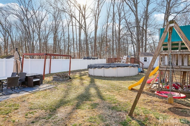 view of yard with a fenced in pool, a fenced backyard, and a playground