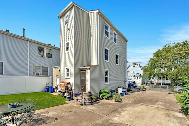 rear view of house featuring a yard, a patio area, and a fenced backyard