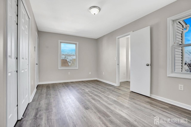 unfurnished bedroom featuring wood finished floors and baseboards