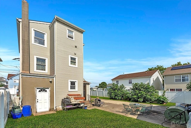 back of property with a patio, a yard, and a fenced backyard