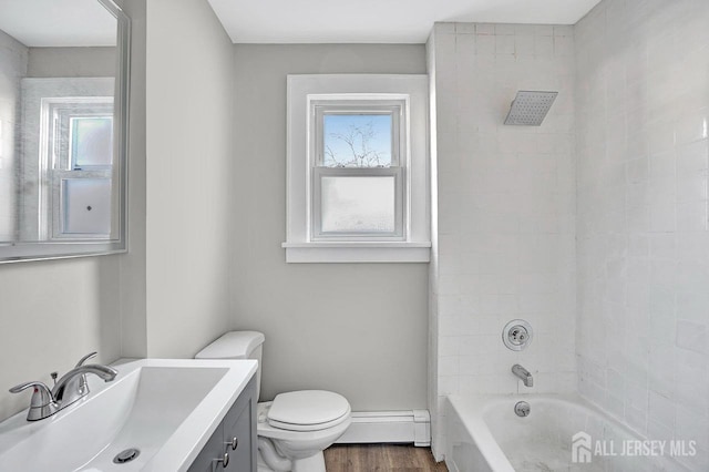 full bathroom with toilet, a baseboard radiator, a wealth of natural light, and vanity