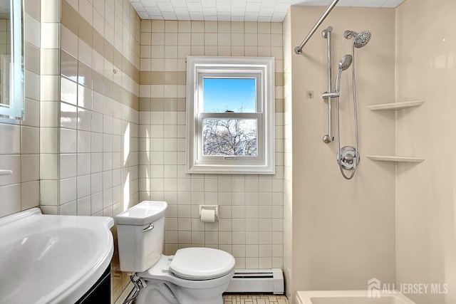 full bathroom featuring a shower, toilet, a baseboard radiator, vanity, and tile walls