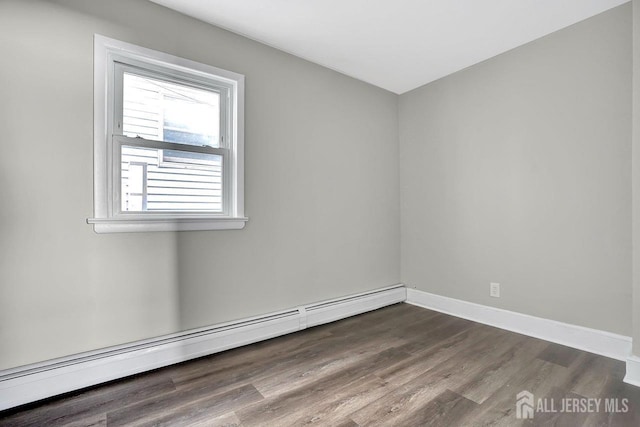 empty room with baseboards, baseboard heating, and dark wood-type flooring