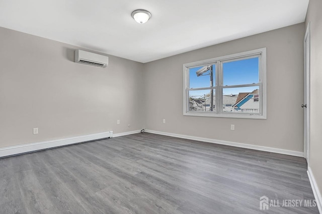 empty room with baseboards, baseboard heating, wood finished floors, and a wall mounted AC