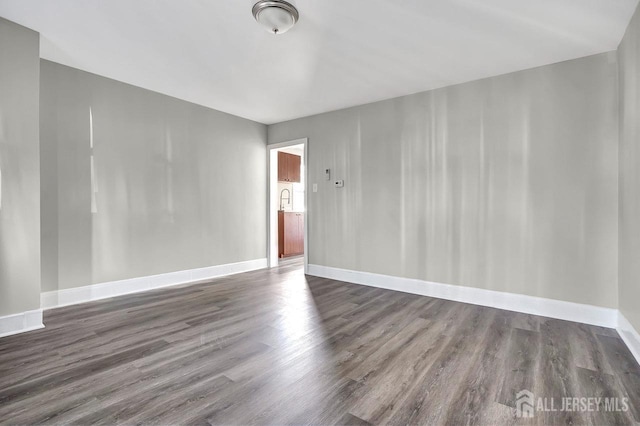 unfurnished room featuring wood finished floors and baseboards